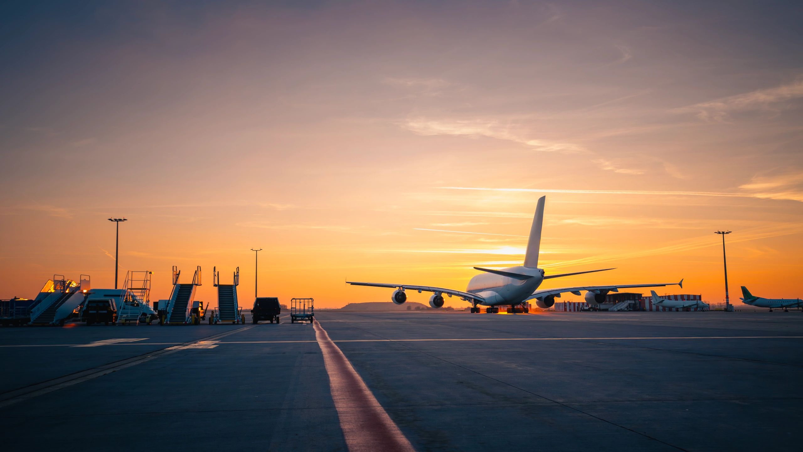 Commercial aircraft taking off at sunset