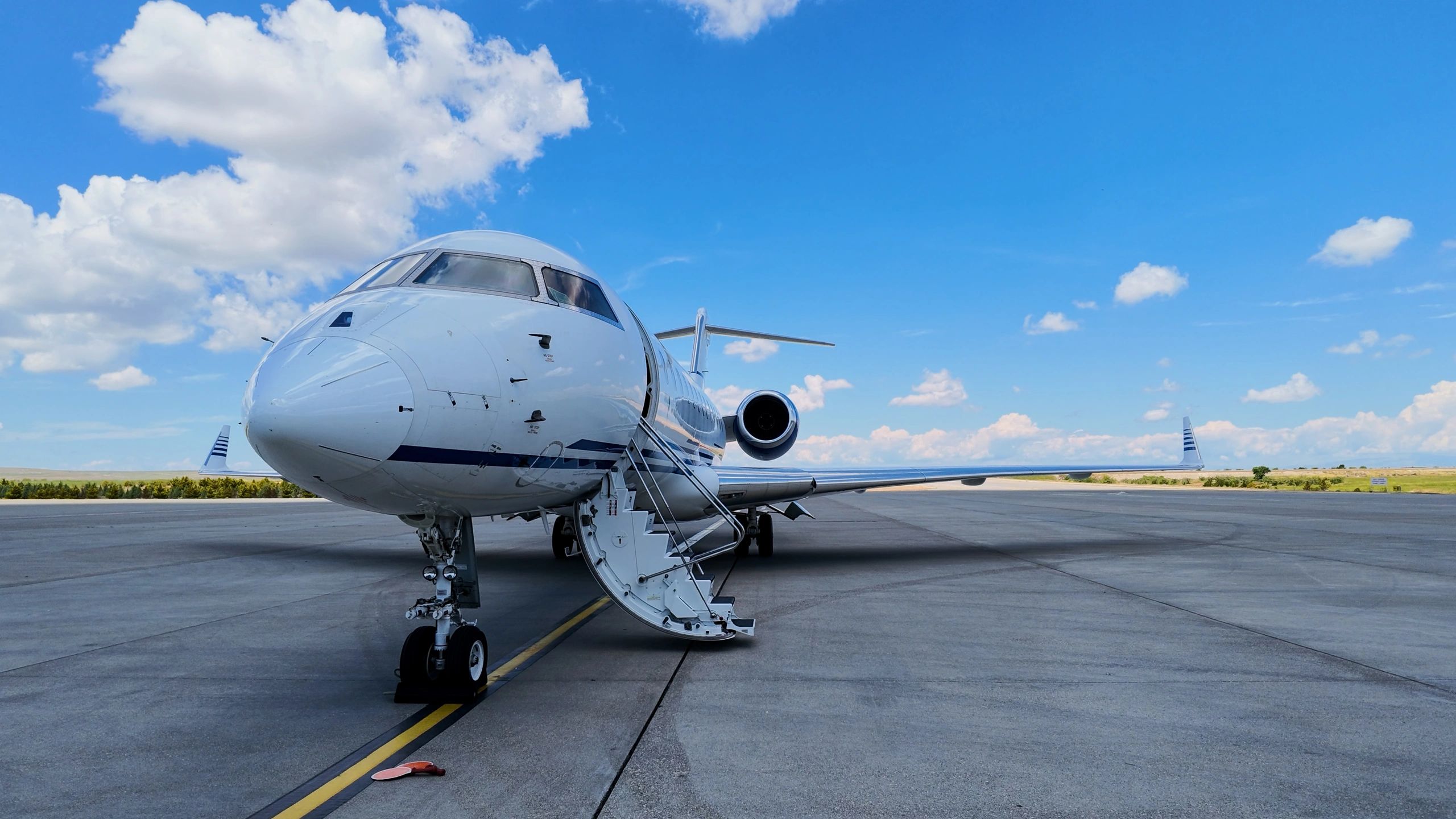 Private jet on apron with engine and landing gear visible